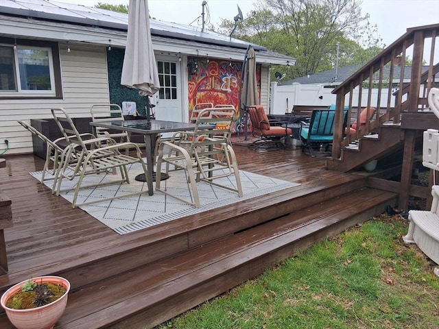 wooden terrace featuring outdoor dining space and stairs