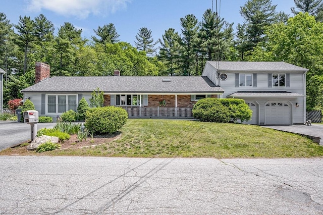 18 Patriot Rd, Tewksbury, MA 01876 - view of front of house featuring driveway, a front yard, a garage, a chimney, and view of scattered trees