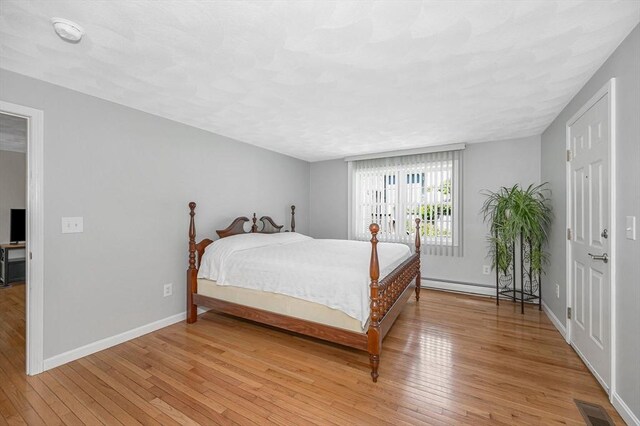 18 Patriot Rd, Tewksbury, MA 01876 - bedroom featuring light wood-style floors, baseboards, and a baseboard heating unit