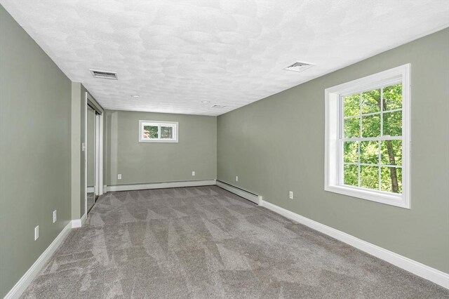 18 Patriot Rd, Tewksbury, MA 01876 - unfurnished room with carpet flooring, a baseboard heating unit, baseboards, and a textured ceiling
