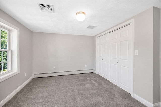 18 Patriot Rd, Tewksbury, MA 01876 - unfurnished bedroom with baseboard heating, carpet flooring, baseboards, and a closet