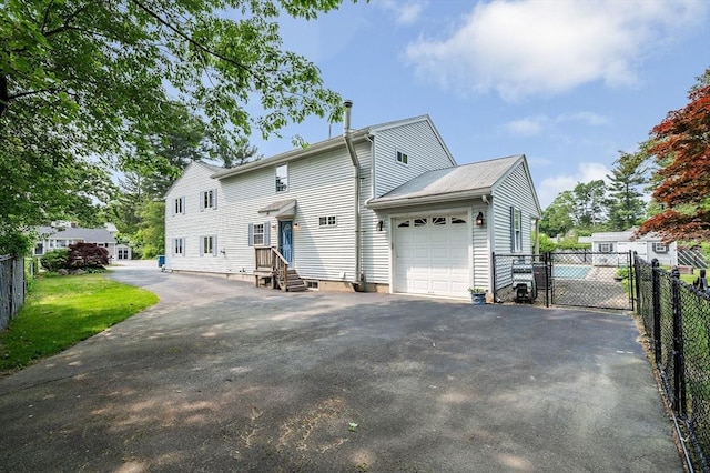 18 Patriot Rd, Tewksbury, MA 01876 - back of house featuring a garage and driveway