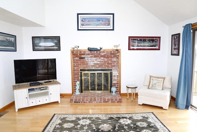 15 Beach St, Falmouth, MA 02536 - living room with wood finished floors, a brick fireplace, vaulted ceiling, and baseboards