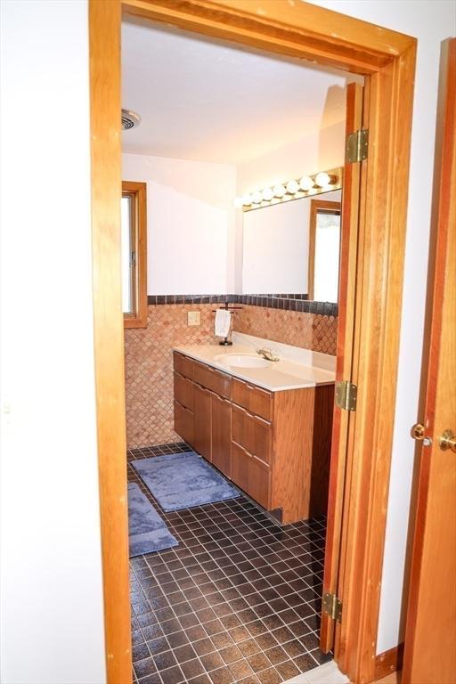 15 Beach St, Falmouth, MA 02536 - bathroom featuring tile walls, vanity, and tile patterned flooring