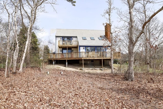 15 Beach St, Falmouth, MA 02536 - rear view of house with a chimney, a wooden deck, a shingled roof, and a balcony