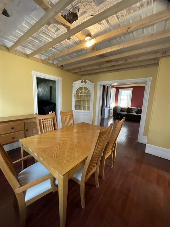 dining room with dark wood-type flooring and baseboards