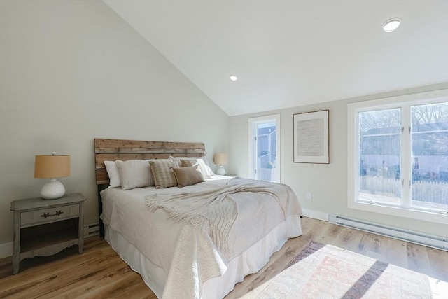 bedroom featuring light wood-type flooring, ensuite bathroom, vaulted ceiling, and a baseboard heating unit