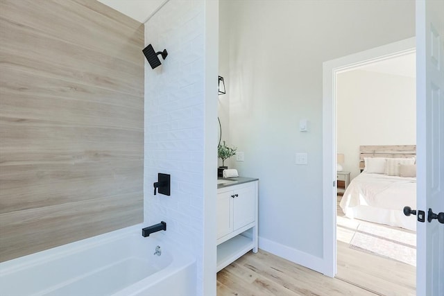 bathroom featuring hardwood / wood-style floors, vanity, and tiled shower / bath combo