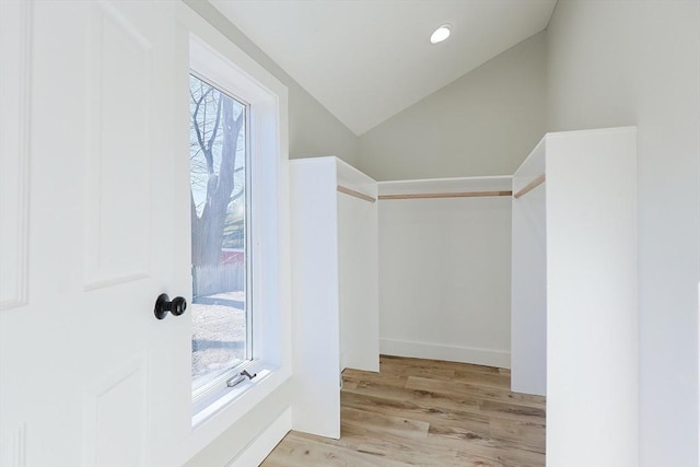 spacious closet featuring light hardwood / wood-style floors and vaulted ceiling