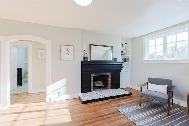 sitting room featuring built in features and light hardwood / wood-style flooring