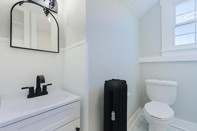 bathroom with radiator heating unit, vanity, toilet, and vaulted ceiling