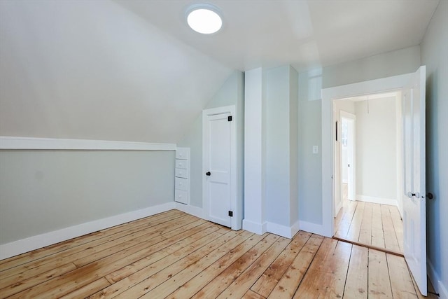 additional living space with lofted ceiling and light wood-type flooring