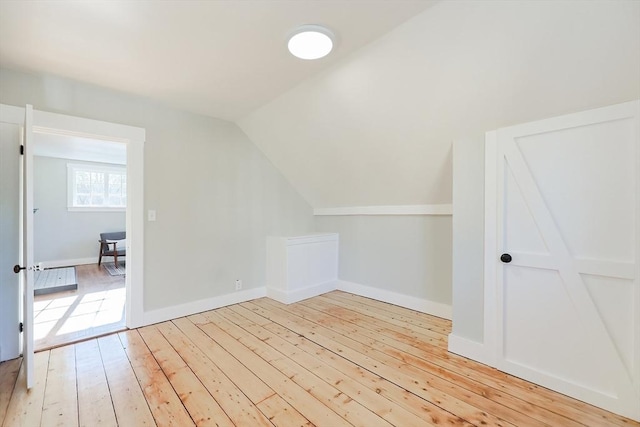 bonus room featuring vaulted ceiling and light hardwood / wood-style flooring