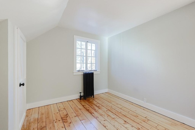 bonus room with radiator, light hardwood / wood-style flooring, and lofted ceiling