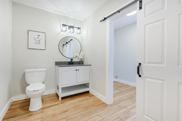 bathroom with hardwood / wood-style flooring, vanity, and toilet