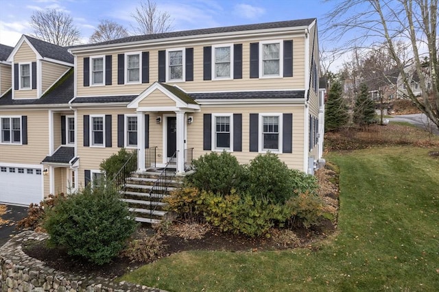 view of front of property featuring a garage and a front lawn