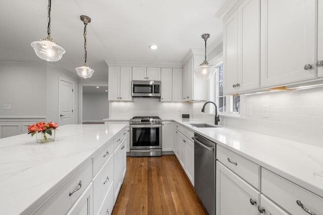 kitchen featuring pendant lighting, white cabinets, sink, decorative backsplash, and stainless steel appliances