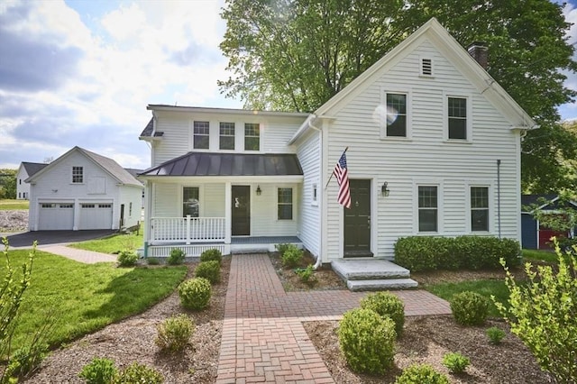74 Main St, Acton, MA 01720 - view of front of property with a porch, a detached garage, a chimney, a front yard, and a standing seam roof