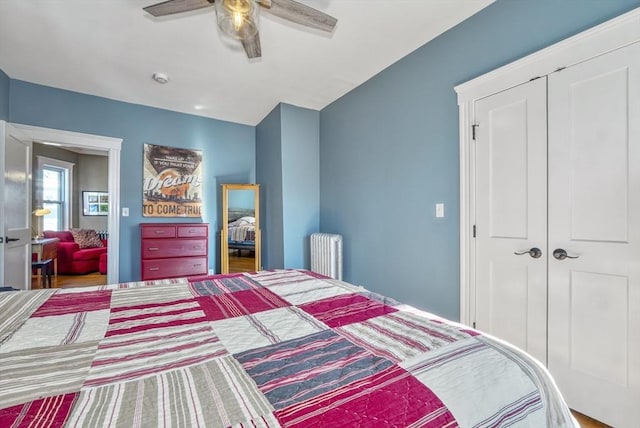 bedroom featuring ceiling fan, radiator, and a closet