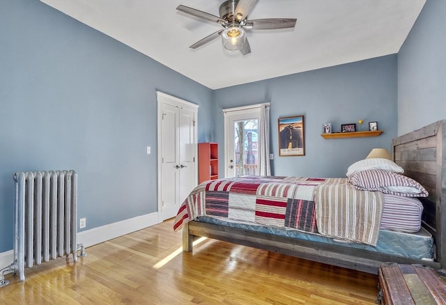 bedroom with radiator, hardwood / wood-style floors, ceiling fan, and access to exterior