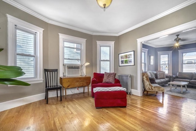 sitting room featuring crown molding, radiator, and a wealth of natural light