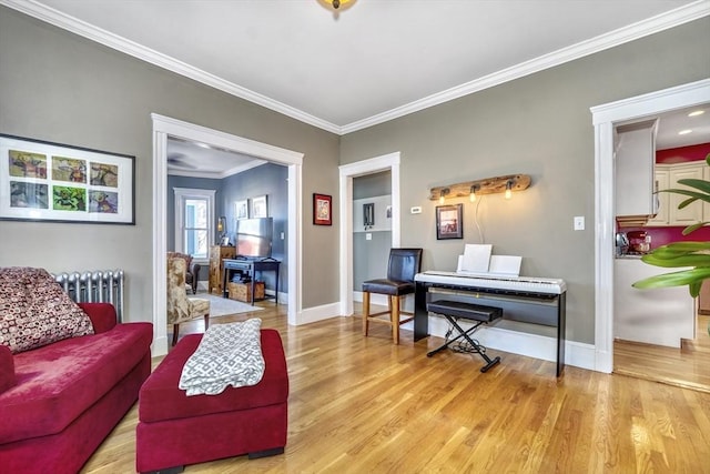 living room with radiator, light hardwood / wood-style flooring, and ornamental molding