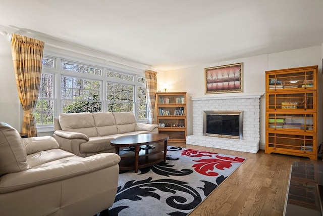 living area with wood finished floors and a brick fireplace