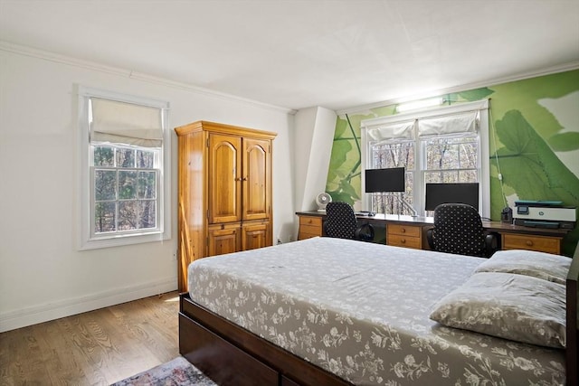 bedroom with ornamental molding, wood finished floors, baseboards, and a desk