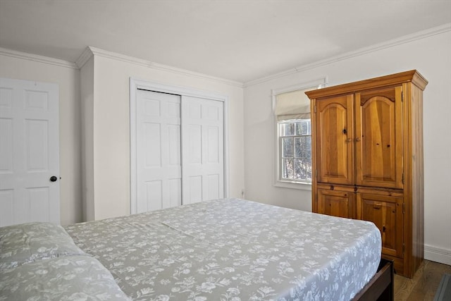 bedroom with wood finished floors, crown molding, and a closet