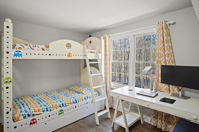 bedroom with wood finished floors and an office area