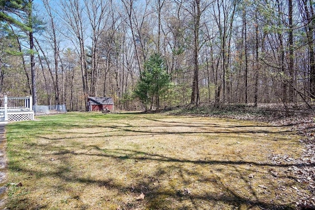 view of grassy yard with a storage unit, an outdoor structure, and a wooden deck
