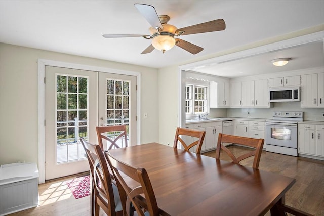 dining space with light wood-type flooring, healthy amount of natural light, a ceiling fan, and french doors