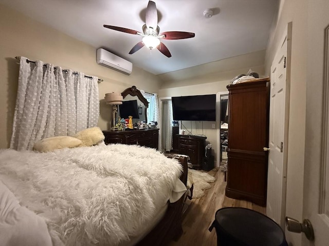 bedroom with a ceiling fan, wood finished floors, and a wall mounted AC