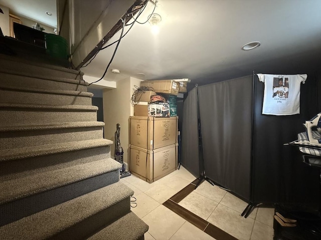 basement featuring stairs and light tile patterned floors