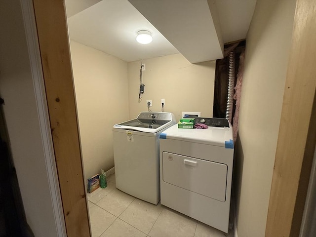 laundry room with laundry area, washing machine and dryer, and light tile patterned flooring