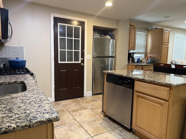 kitchen with appliances with stainless steel finishes, recessed lighting, stone counters, and backsplash