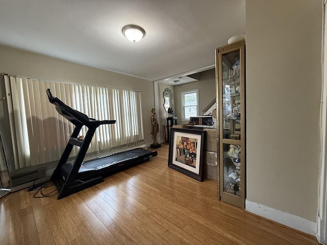 exercise area featuring baseboards and hardwood / wood-style floors