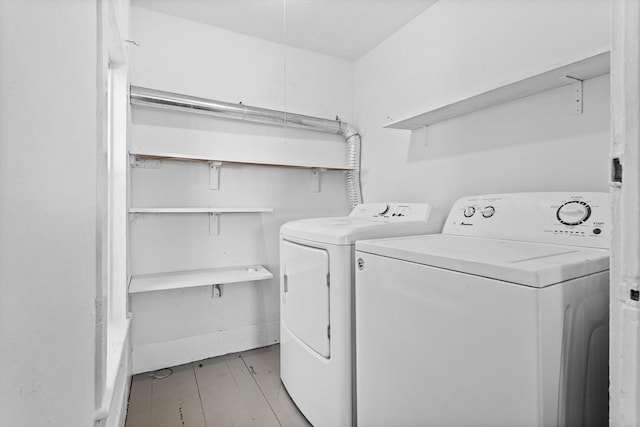 washroom with light hardwood / wood-style floors and washer and dryer