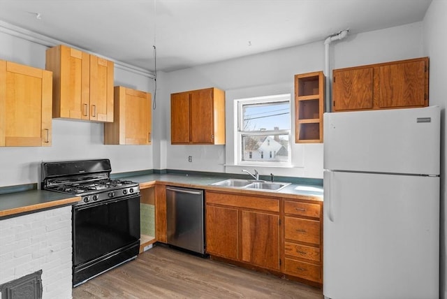 kitchen with sink, dishwasher, white refrigerator, wood-type flooring, and gas stove