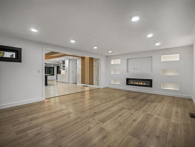 820 N King St, Northampton, MA 01060 - unfurnished living room with wood finished floors, recessed lighting, and a glass covered fireplace