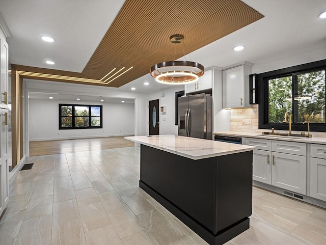 820 N King St, Northampton, MA 01060 - kitchen with stainless steel fridge, open floor plan, a kitchen island, light stone countertops, and pendant lighting