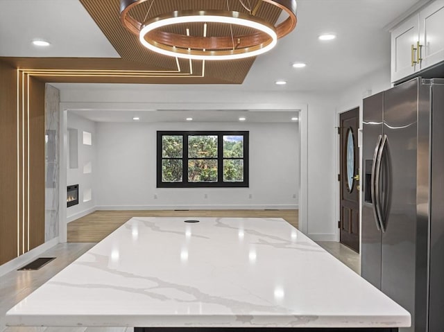 820 N King St, Northampton, MA 01060 - kitchen featuring stainless steel fridge with ice dispenser, light stone countertops, recessed lighting, open floor plan, and a kitchen island