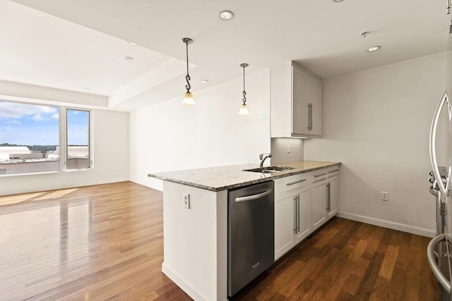 10 Nouvelle Way Unit S703, Natick, MA 01760 - kitchen with appliances with stainless steel finishes, a sink, a peninsula, dark wood-style floors, and light stone counters