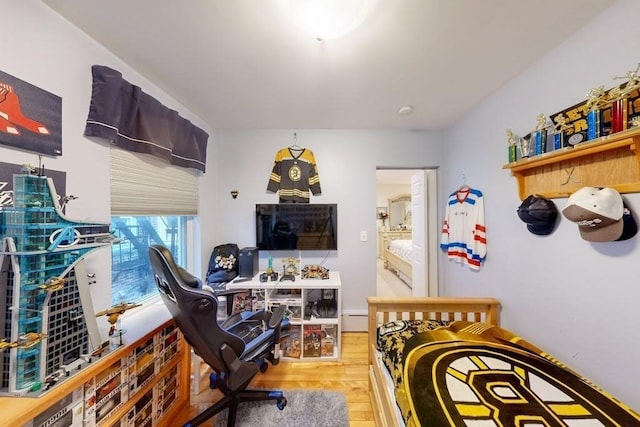 bedroom with light wood-style flooring and a baseboard radiator