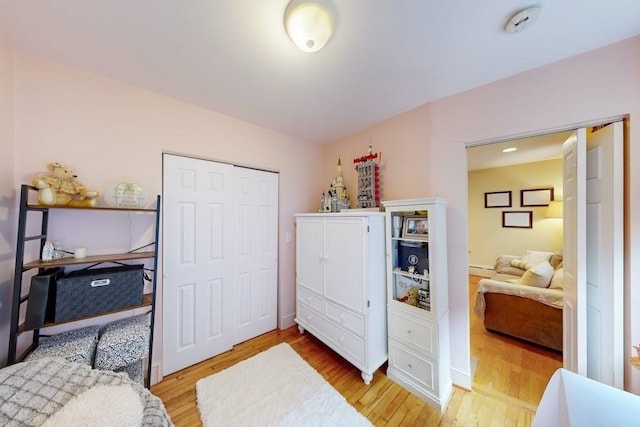bedroom with light wood-style floors and a closet