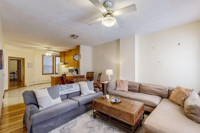 living room with baseboard heating and ceiling fan