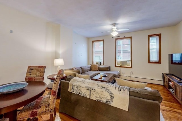 living room featuring a baseboard heating unit, wood finished floors, ceiling fan, and cooling unit