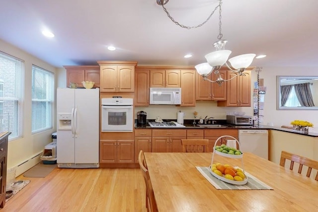 kitchen with white appliances, a baseboard radiator, a chandelier, a sink, and wooden counters