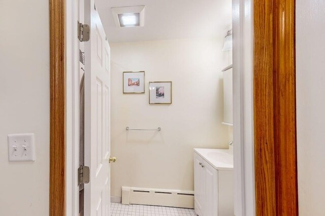 bathroom featuring a baseboard heating unit, vanity, and baseboards