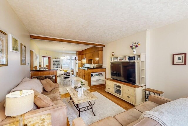 living area featuring light wood-style flooring and a chandelier